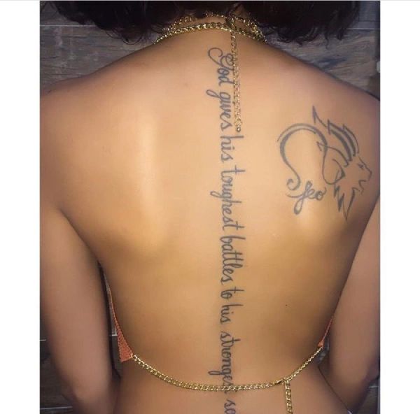 the back of a woman's body with tattoos on it