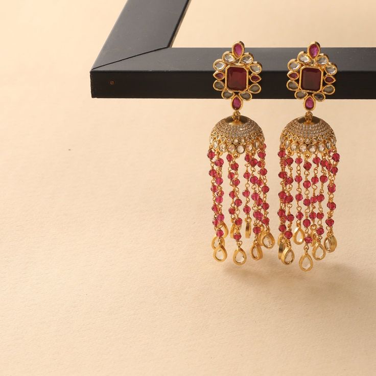 Description: These jhumki earrings from Tarinika are a classic piece with a statement yet simple style. It showcases polki stones set on a floral arrangement having a jhumki drop with beads chain on a gold-plated base. The beaded chains and the minimal design add to its sophistication and richness. Details & Specifications: Materials used: Brass Alloy with Yellow Gold Plating Weight - Earrings 29.13 gm Length - Earrings 9 cm Make it custom Want to make it a custom earring? Sure! Reach out to us Buy Jewellery Online, Jhumki Earrings, Traditional Earrings, Indian Jewellery Design, Beads Chain, Indian Earrings, Antique Necklace, Custom Earrings, Kundan Jewellery