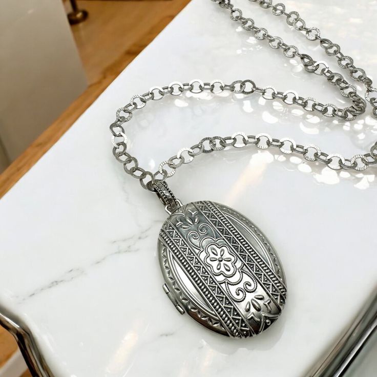 Hello and welcome, Gorgeous in perfect condition piece here. Solid sterling silver, this thick pendant opens up to hold and treasure 42 photos. Will make an amazing gift for any lady. Cleaned and polished inside and out. Marked 925 and features Silpada charm logo. Comes with an 30" large circle chain, also stamped 925. Locket is approximately 2" long, about 1-11/16" wide. Elegant Engraved Locket Necklace With Oval Link, Antique Silver Locket Necklace With Oval Pendant, Antique Silver Oval Pendant Locket Necklace, Antique Silver Oval Pendant Necklace With Locket, Antique Silver Necklace With Oval Locket Pendant, Heirloom Oval Link Locket Necklace, Classic Silver Locket Necklace With Oval Link, Classic Silver Oval Link Locket Necklace, Heirloom Silver Locket Necklace With Oval Pendant