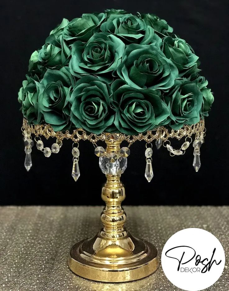 a gold and green flower arrangement on a stand with crystal beaded beads, crystals and chains