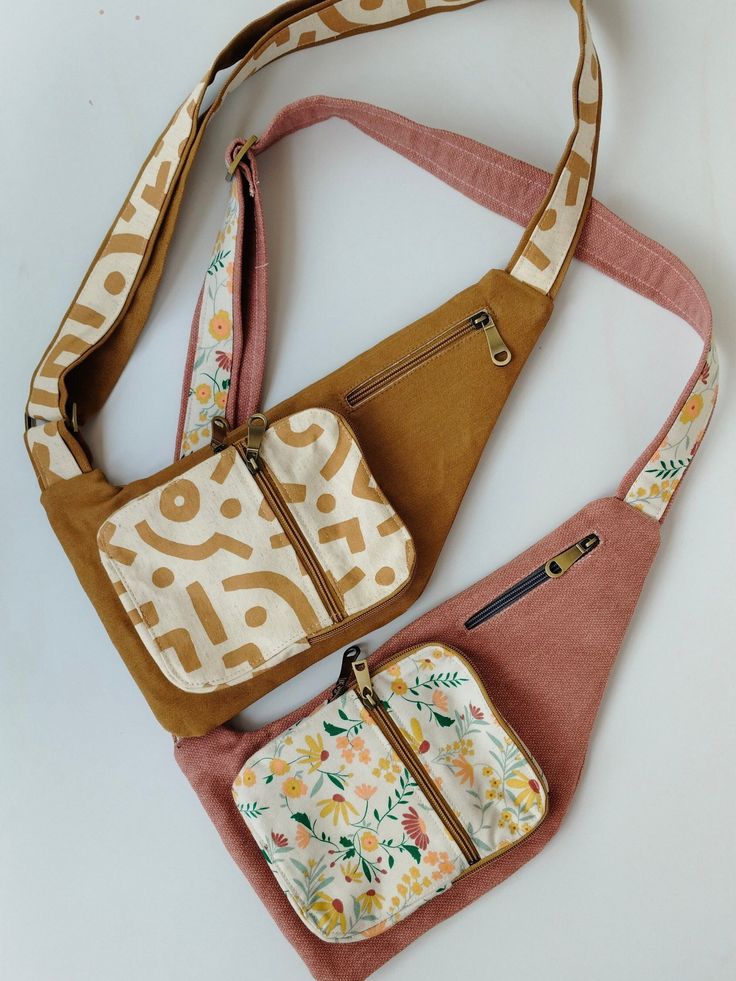 three purses are sitting next to each other on a white surface, one is brown and the other is pink