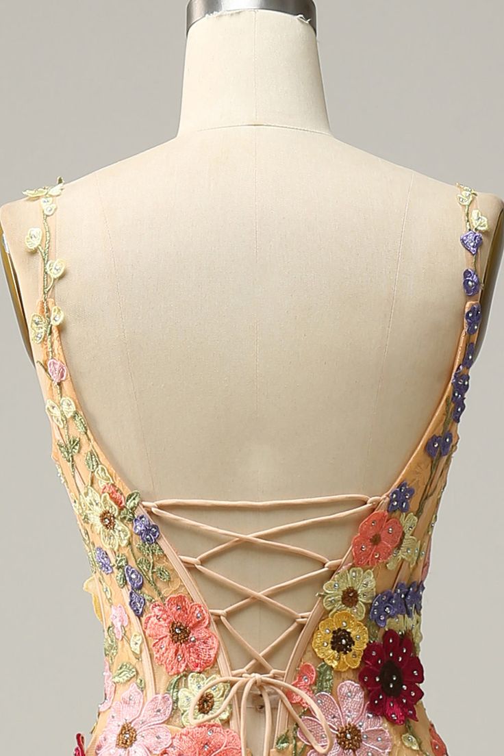 the back of a dress with flowers on it and laces at the neckline