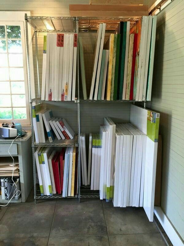 a book shelf filled with lots of books on top of a tiled floor next to a window