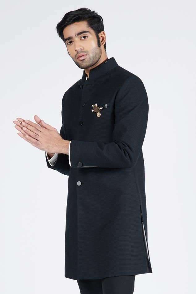 Black textured sherwani features faux leather on the Nehruvian collar and faux leather buttons.
Components: 1
Neckline: Nehru Collar
Sleeve Type: Straight Full
Fabric: Cotton Pleated Fabric
Color: Black
Other Details: 
Note: Shirt, pant and brooch worn by the model is not for sale
Occasion: Sangeet - Aza Fashions Traditional Black Kurta For Groom, Traditional Drape Black Kurta For Groom, Black Bandhgala For Groom With Traditional Drape, Black Traditional Wear For Groom, Formal Black Sherwani With Naqshi Detailing, Black Bandhgala With Zari Work, Ceremonial Black Kurta With Naqshi Detailing, Ceremonial Black Kurta With Naqshi, Ceremonial Nehru Jacket With Traditional Drape