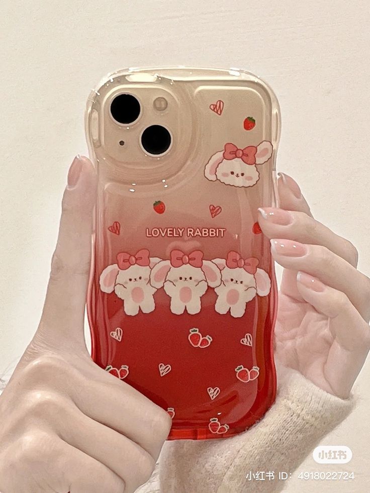 a person holding up a cell phone case with bears on the front and hearts on the back