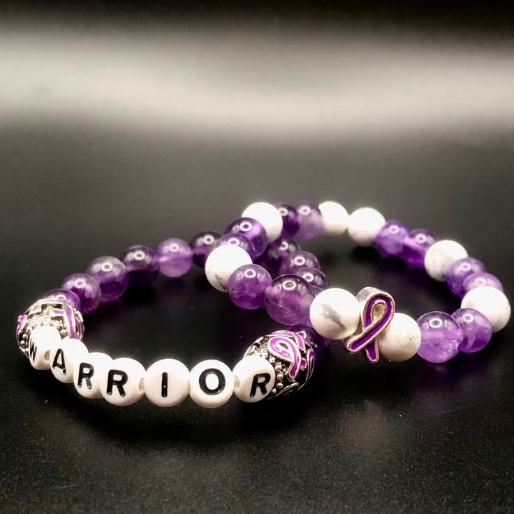 "November is Epilepsy Awareness Month. 50% of all sales through November 30th will be donated to the Epilepsy Foundation.  These Limited Edition Bracelets are made of Amethyst Beads to represent the color of Epilepsy Awareness.  Amethyst is believed to sooth the body mind and soul.  The Warrior Bracelet is made specially for those with Epilepsy to remind them that they are WARRIORS!   The Ribbon Bracelet contains white marble stone beads and a Purple Ribbon Charm to show support and to raise awareness for Epilepsy.  Both Bracelets come on an elastic band. You May choose the unstrentched width to be 6\", 6.5\", 7\", 7.5\", or 7.75\". Please be aware that for the ribbon bracelet, the pattern may vary slightly to fit the requested width.  Please Note: Both Bracelets contain Metal.  To learn m Purple Beaded Crystal Bracelet For Friendship, Purple Stretch Bracelet With Gemstone Beads As Gift, Purple Gemstone Beads Stretch Bracelet As Gift, Purple Hand-strung Stretch Bracelet As Gift, Purple Hypoallergenic Crystal Bracelet Gift, Purple Spiritual Jewelry For Friendship, White Amethyst Beaded Bracelets, Spiritual Purple Beaded Bracelets For Friendship, Purple Stretch Bracelet With 8mm Beads For Friendship