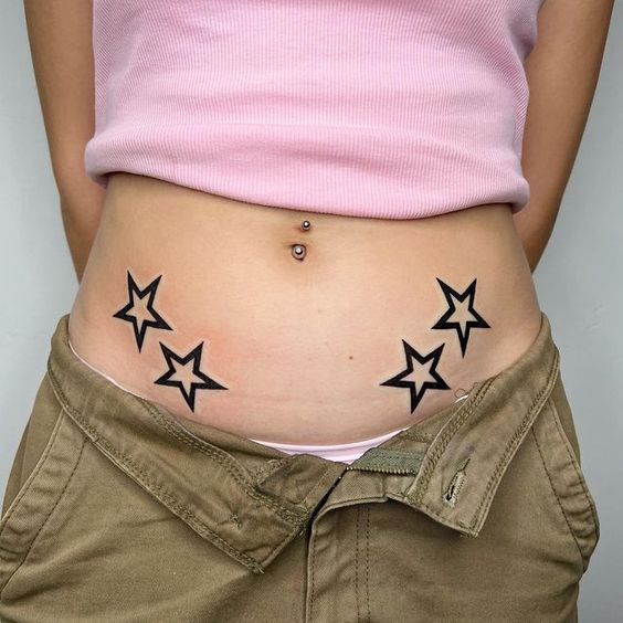 a woman's stomach with black stars on it