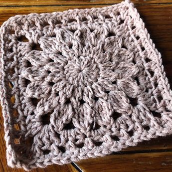 a crocheted square sitting on top of a wooden table