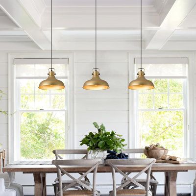 a dining room with white walls and wooden table surrounded by chairs, potted plants and two large windows