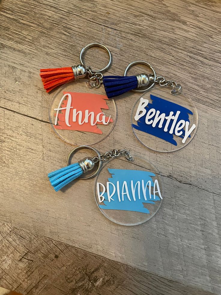 three personalized acrylic key chains with tassels