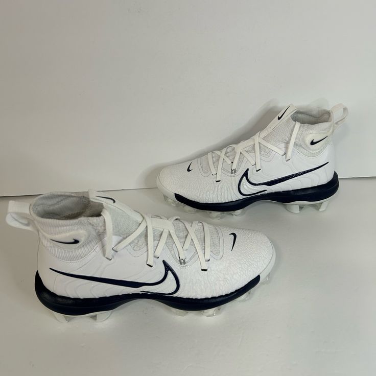 a pair of white and blue shoes sitting on top of a table next to each other