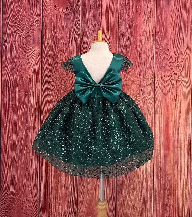 Sequin Pearl Dress This beautiful elegant dress is handmade, bodice is made of bridal satin with a short beaded cap sleeve, the back of the dress consists of a deep V-back with a zipper. The big bow has a pin to be attached to the dress and it's removable if needed. The skirt consists of multi layers, the top layer consists of sequin & pearls, 3 layers of tulle, 2 layers of lining with crinoline for fullness.  Dress Is Pictured with a petticoat NOT INCLUDED https://www.etsy.com/listing/1316417982/white-knee-length-petticoat-wedding?click_key=41cb8b0ae4587efa582b0a433f3f5e0cde12aec0%3A1316417982&click_sum=af1df37b&ref=shop_home_active_1 Matching hair bow https://www.etsy.com/listing/1405032366/satin-big-bow-hair-clip-flower-girl?click_key=91c1fea2f7cd1e7b097d731e925a67b789621873%3A140503236 Christmas Church, Pearl Dress, Photoshoot Dress, Big Bow, Bow Hair Clips, Toddler Dress, Birthday Girl, Flower Dresses, Hunter Green