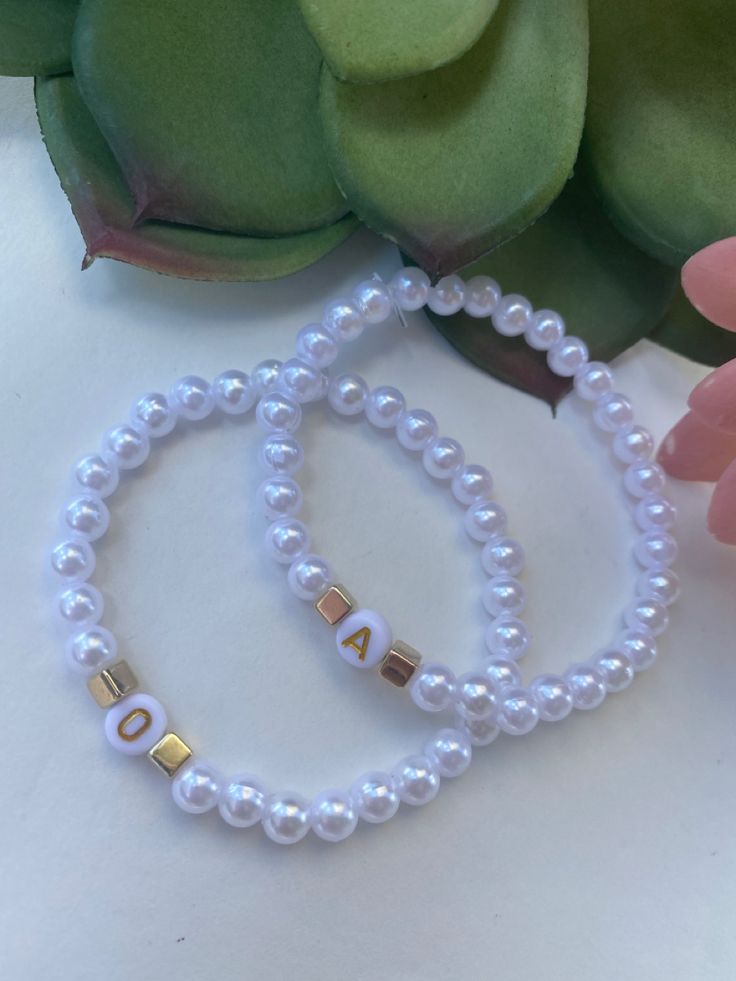 Bracelets are made with white pearl beads. These bracelets are great to wear with any attire. 😉 Bracelets measure between 7” and 7.5”. which is the standard size. “ Can be made smaller if specified at checkout. Please list the letter you will like on your bracelet in the personalized section. ** All Sales Are Final*** Thanks for shopping with us 😉❤️😘 Bracelets With Pearl Beads, Bracelet Business Logo Ideas, Letter Beads Bracelet, Bracelet Pearl Ideas, Bracelet Ideas With Pearls, Letter Beads Ideas, Letter Bracelet Beads Ideas, Pearl Bracelet Ideas, Letter Bracelet Beads