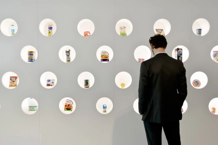 a man standing in front of a wall with circles on it