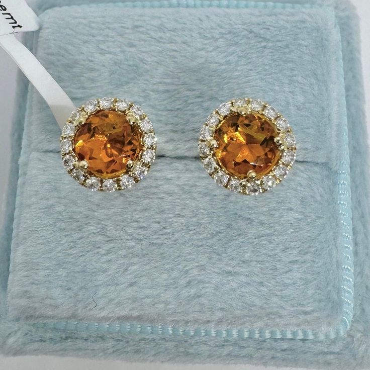 Beautiful Round Halo Citrine and Diamond Stud Earrings Yellow Gold.  Simple and classy earrings.  Excellent craftsmanship, the halo of diamonds frame the citrine beautifully.  The diamonds are very sparkling.  The halo measures about 7.7mm.   The push backings have 2 security notches for a secure fit.  The backs are big and strong.  These small dainty studs are great for everyday wear.   Genuine citrine 5mm round cuts  Total weight: 0.87 carats Genuine round brilliant cut diamonds  Total weight: 0.23 Clarity: SI Color: G Solid 18K Yellow Gold 2.13 grams  Comes with gift box AT1700 * We have been in the wholesale Jewelry business for over 30 years serving the community at the same location.  All diamonds we use are natural stones and fine quality gold.  Absolutely NO clarity enhanced or tre Luxury Citrine Earrings, Formal Yellow Gold Cluster Earrings With Halo Setting, Formal Halo Cluster Earrings Fine Jewelry, Formal Halo Cluster Earrings, Yellow Gold Topaz Earrings, Round Shape, Orange Earrings For Anniversary In Fine Jewelry Style, Formal Round Citrine Earrings, Formal Topaz Earrings With Prong Setting, Fine Jewelry Topaz Earrings For Wedding