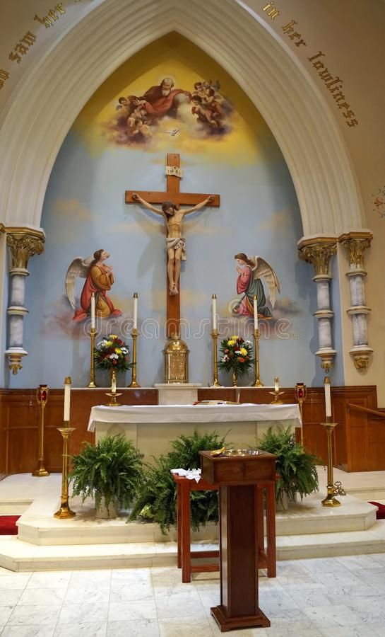 an altar with flowers and candles in front of the crucifix on display