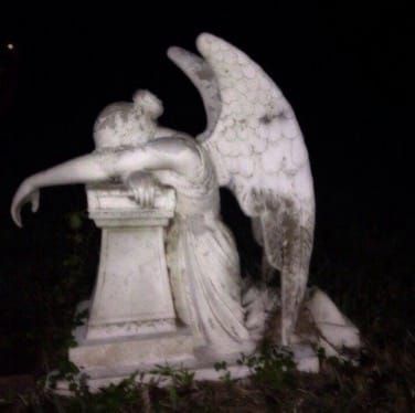 an angel statue sitting on top of a white pedestal