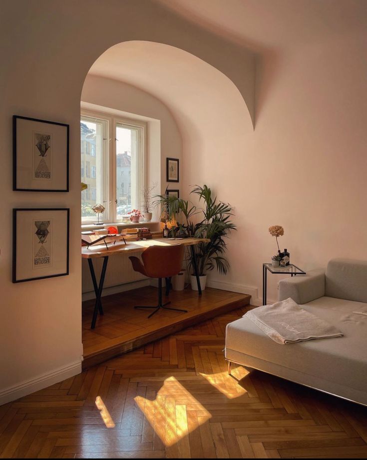 a living room with a couch, table and pictures hanging on the wall next to it