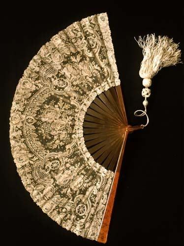 an old lace fan with tassels on it