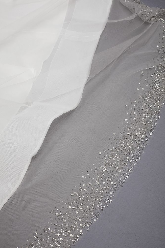 a white wedding dress with silver sequins on the bottom, and sheer fabric