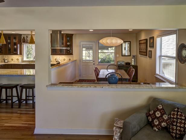 an open kitchen and living room are seen from the dining room through to the family room