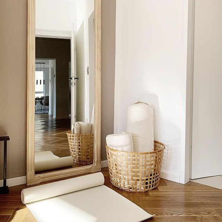 a large mirror sitting on top of a wooden floor next to a roll of paper