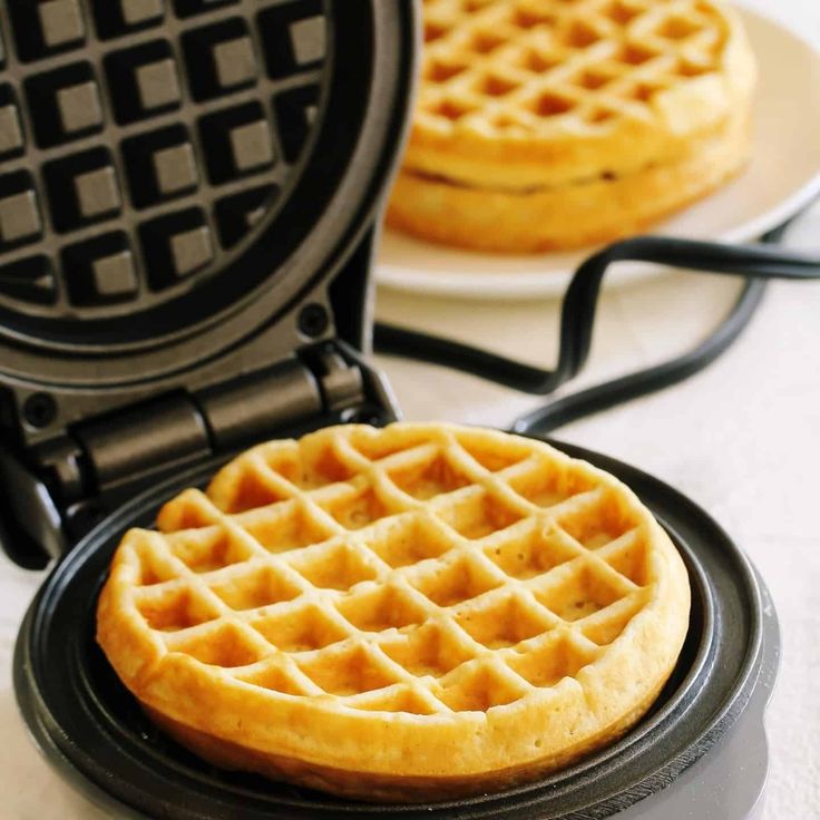 two waffles sitting on top of a black plate next to eachother