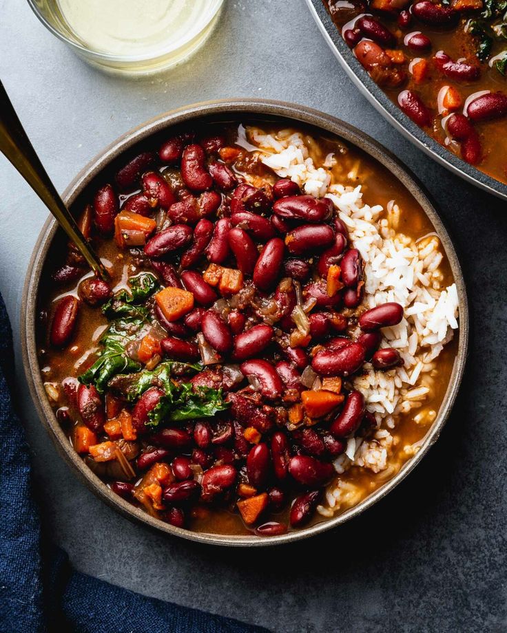 two bowls filled with beans and rice on top of a table