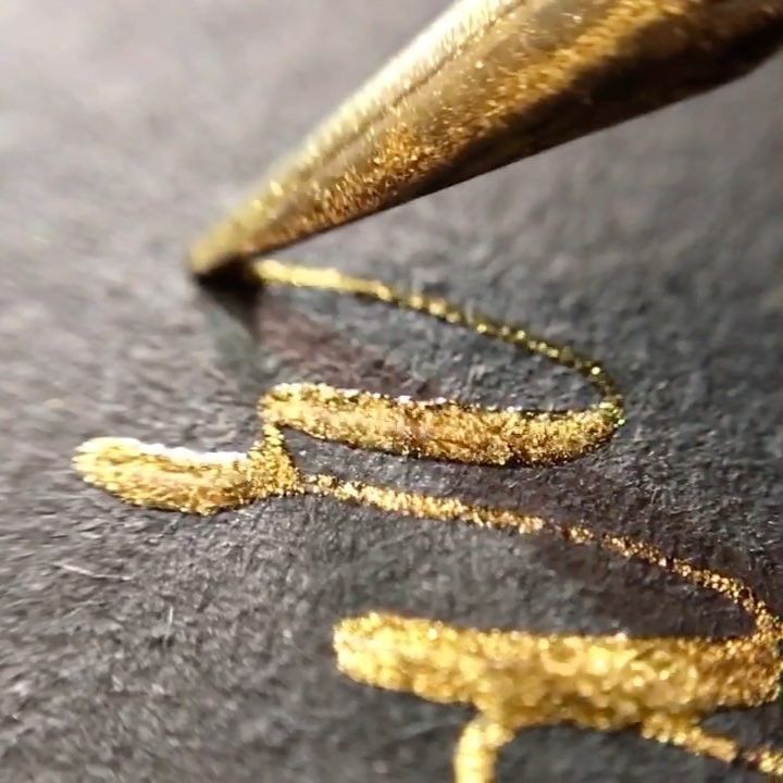 a close up of a gold colored object with writing on it