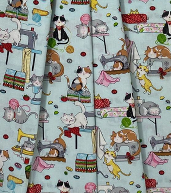 the fabric has cats and sewing machines on it