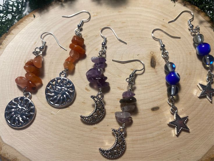 Add a touch of celestial elegance to your outfit with these stunning dangly crystal stacked drop earrings, available in 3 beautiful variations. Choose from Southern red agate adorned with a charming sun, mesmerizing amethyst featuring a delicate moon, or protective evil eye beads embellished with a sparkling star. Each pair is meticulously handcrafted to add a touch of bohemian flair to any look. Elevate your style with these unique and stylish earrings that will surely turn heads wherever you g Celestial Crystal Earrings With Moon Charm As Gift, Handmade Adjustable Spiritual Crystal Earrings, Celestial Round Crystal Earrings As Gift, Silver Celestial Crystal Earrings As Gift, Handmade Mystical Crystal Earrings As Gift, Celestial Round Crystal Earrings For Gift, Silver Celestial Crystal Earrings For Gift, Handmade Celestial Crystal Earrings For Gift, Spiritual Crystal Earrings With Natural Stones For Gift