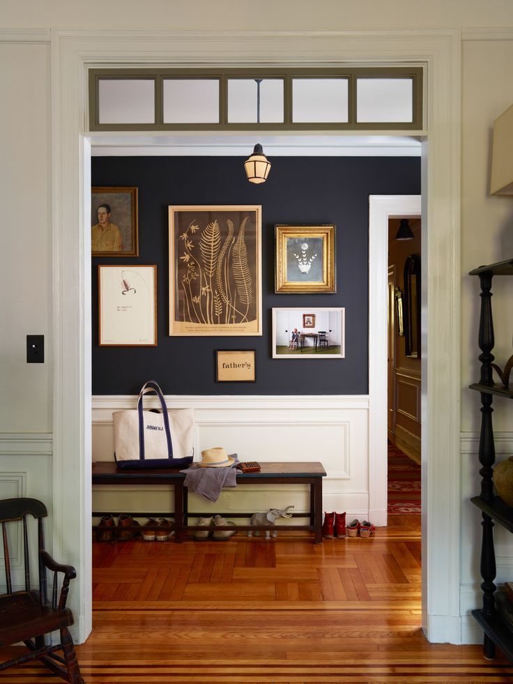 an open door leading to a living room with pictures on the wall and wooden floors