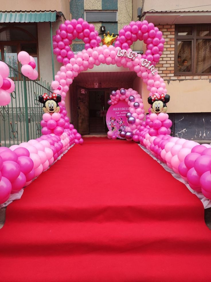 a red carpet with minnie mouse balloons on it