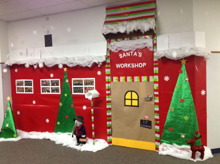 an office decorated for christmas with santa's workshop on the front door and decorations