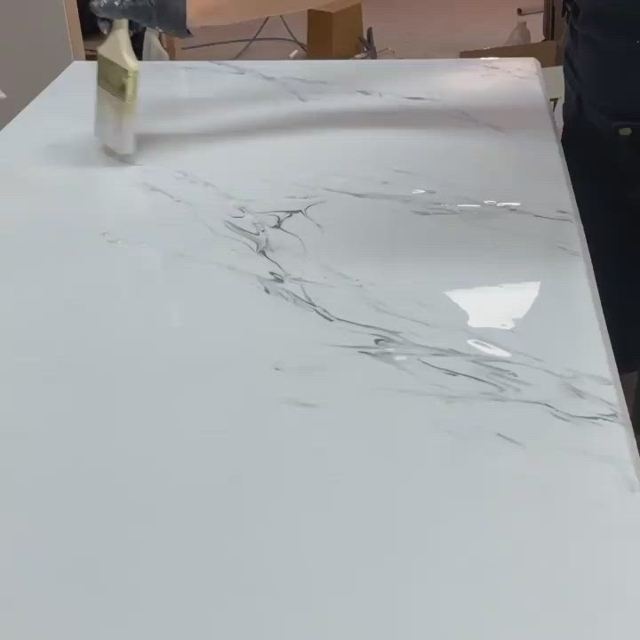 This may contain: a man is painting a white marble counter top