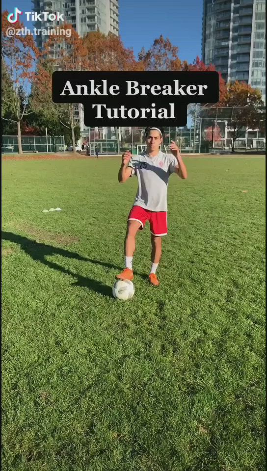 This may contain: a man standing on top of a lush green field holding a soccer ball in his hands