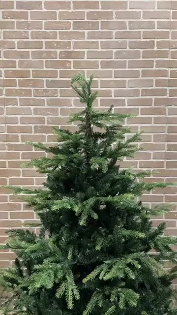 This may contain: a woman is placing candles on a christmas tree