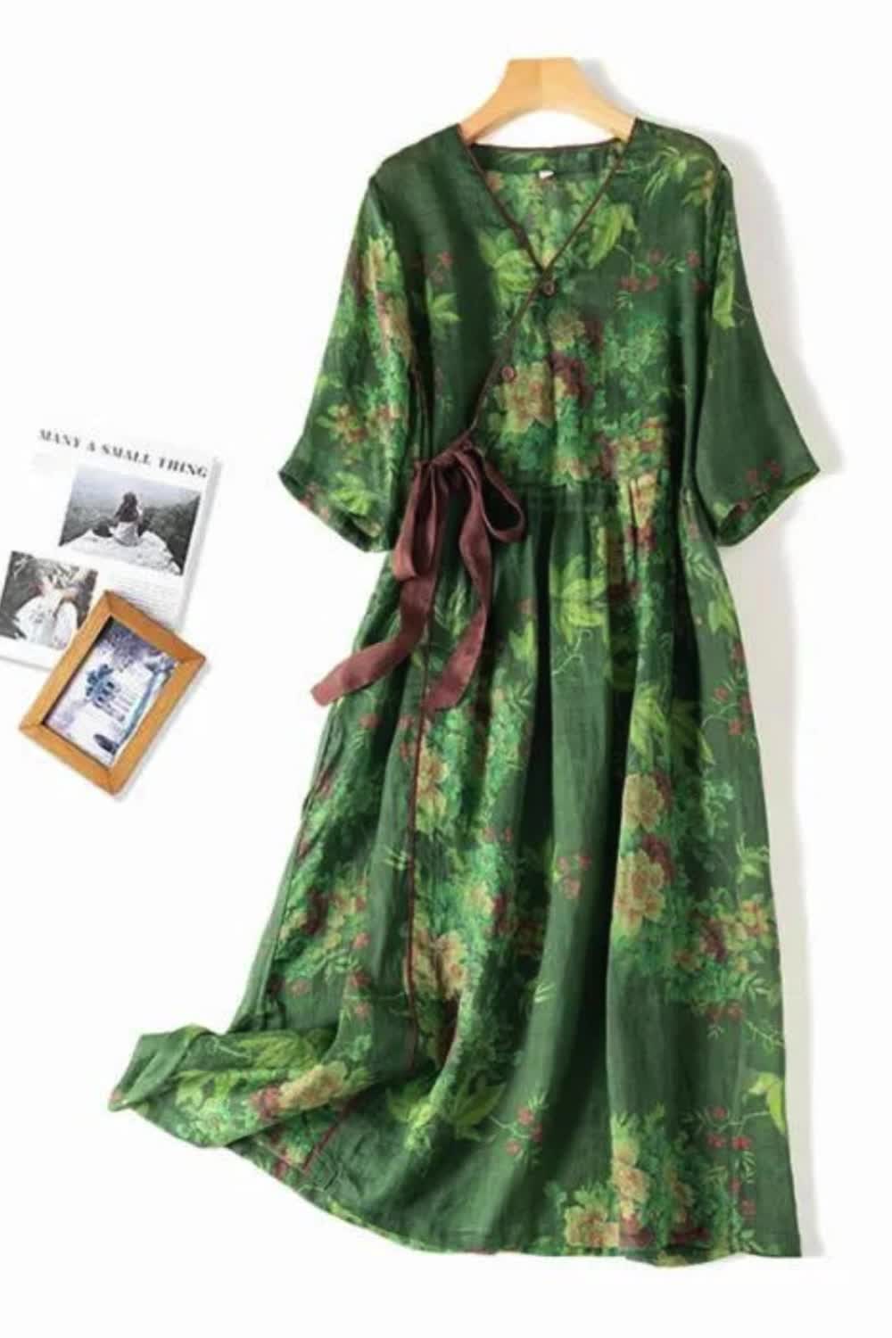 This Green Floral Print Vintage Dress combines elegance with comfort. Made from linen, it features a V-neck, lace-up front, and a loose fit for a relaxed yet stylish look. The mid-calf length and floral pattern make it perfect for any casual or semi-formal occasion.