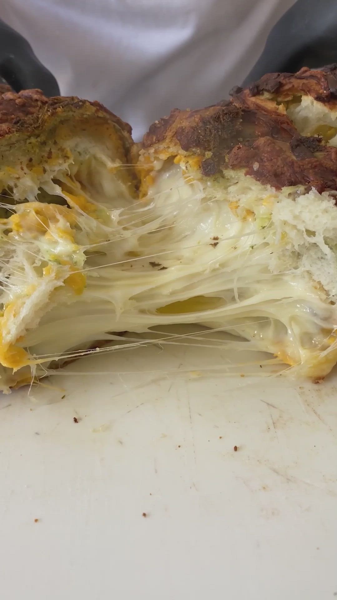 This may contain: a close up of food on a table with the words loaded baked garlic and pesto bread