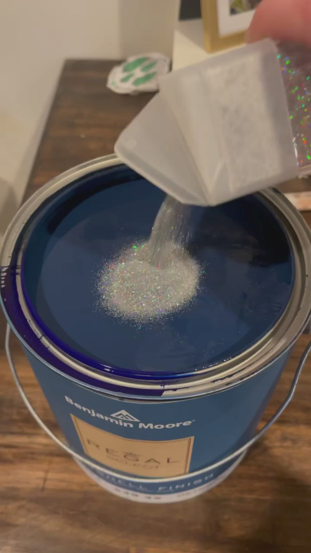 This may contain: someone is pouring something into a blue paint can