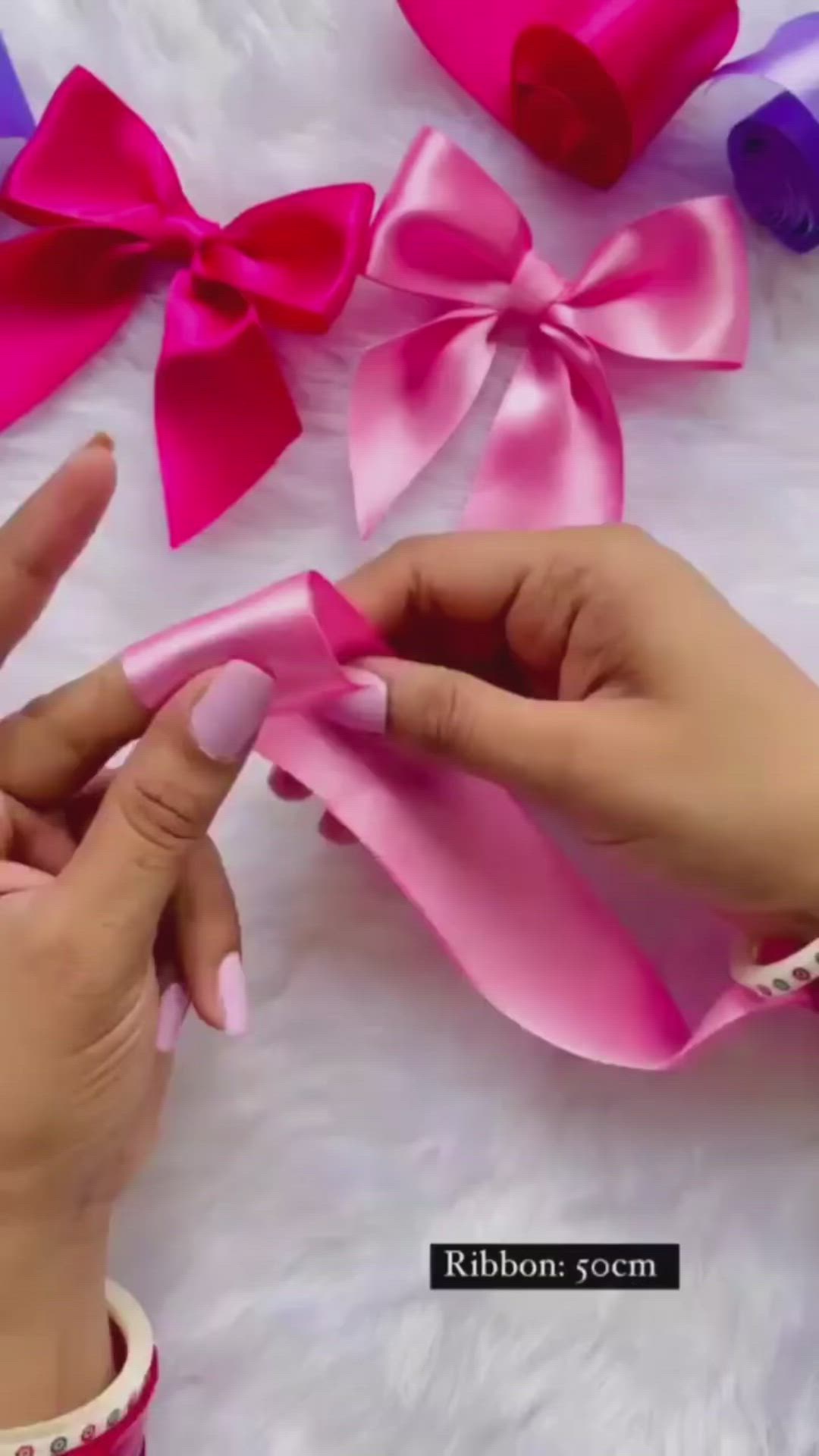 This may contain: someone is making pink and purple bows for their hair