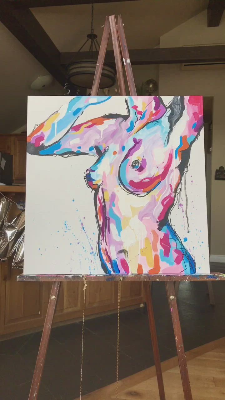 This may contain: a woman is painting on an easel with colorful paint