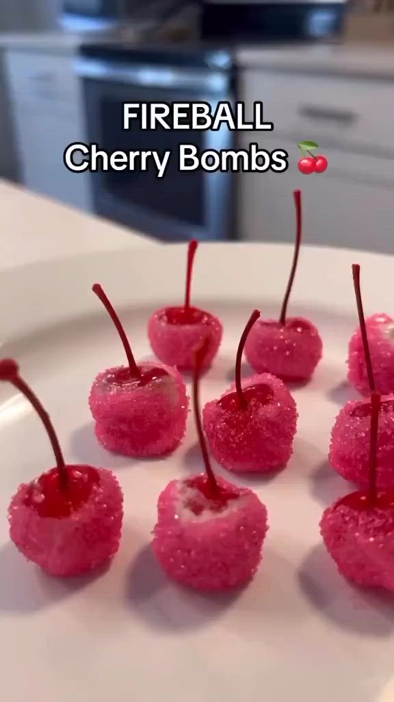 This may contain: small cherries on a white plate covered in pink sugar and sprinkles