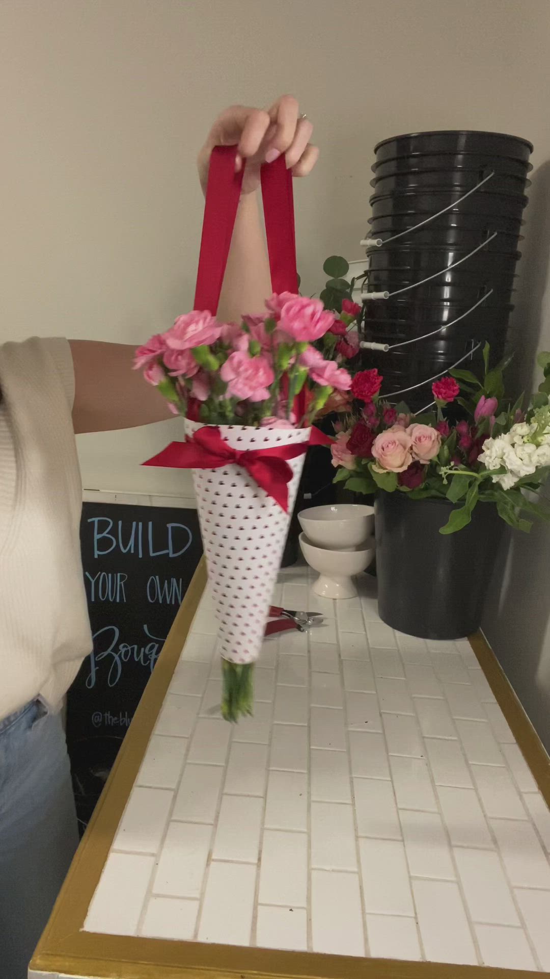 This may contain: a woman holding up a bouquet of flowers