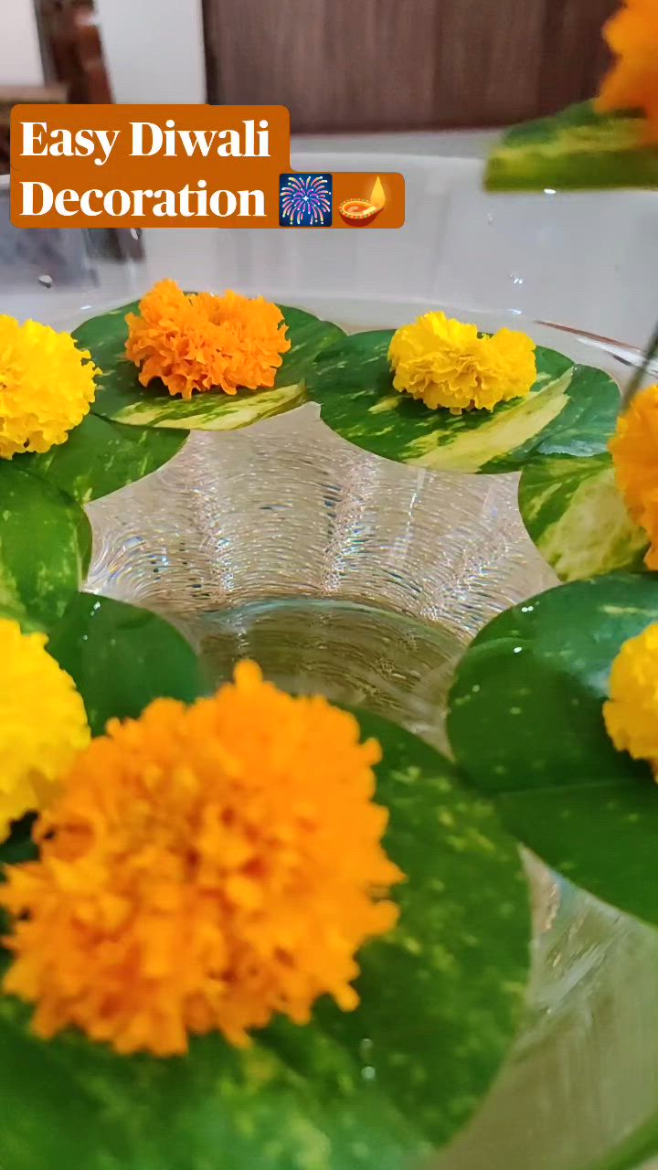 This may contain: an easy diwali decoration with flowers in a glass bowl on a wooden table