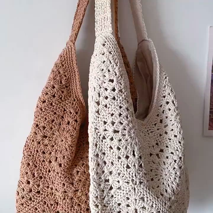 This may contain: two crocheted purses hanging on a wall, one is brown and the other is white