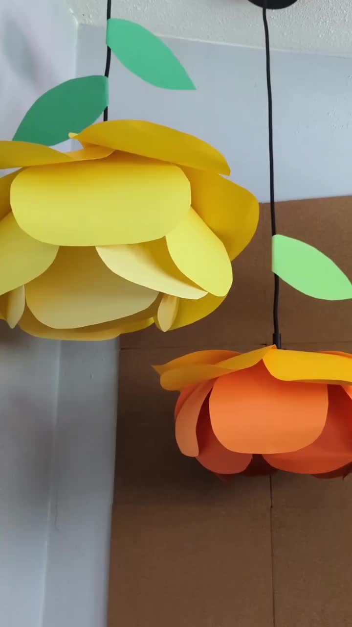 This may contain: some paper flowers hanging from the ceiling