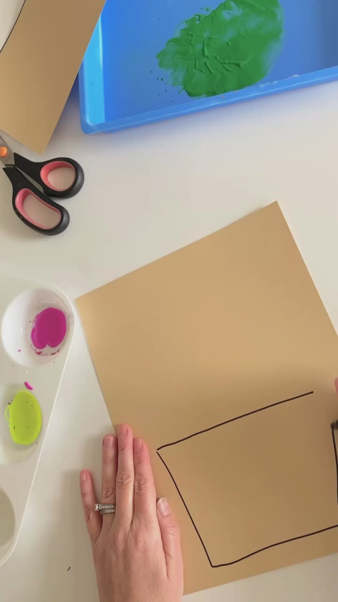 This may contain: a child's hand with flowers painted on it, sitting next to a piece of paper