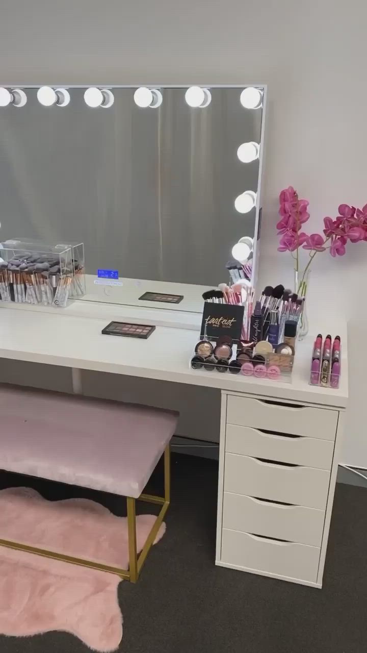 This may contain: a vanity with lights and makeup on it