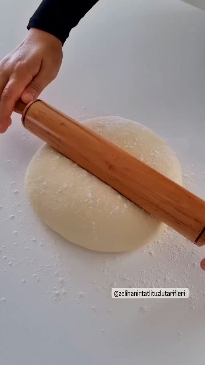 This may contain: a pan filled with food sitting on top of a white counter next to a person's hand